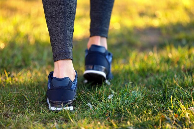 Mette in mostra le gambe della donna in scarpe da ginnastica all'aperto