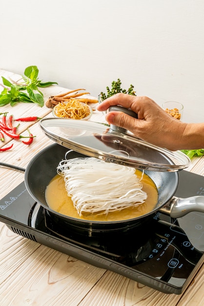 mettendo i noodle in padella con salsa