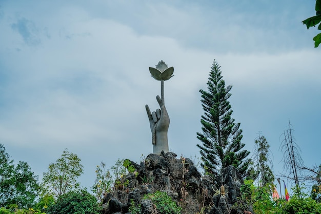 Mettere a fuoco la mano della statua che tiene il loto nel monastero centrale Il monastero di Chon Khong è un antico tempio