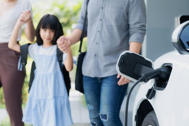 Metti a fuoco la stazione di ricarica domestica per la famiglia progressiva di sfocatura auto EV sullo sfondo