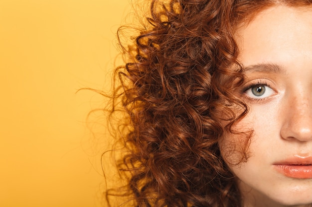 Mezza faccia da vicino di una donna calma rossa riccia