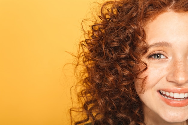 Mezza faccia da vicino di una donna sorridente rossa riccia