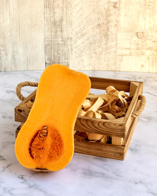 Mezza zucca accanto a una scatola di legno.