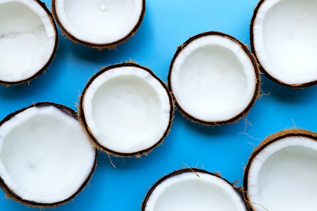 Mezze noci di cocco su fondo blu.