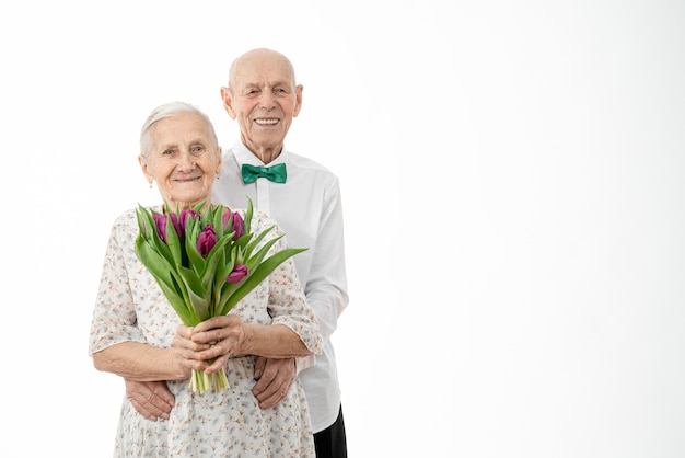 Mezzo busto ritratto delle vecchie coppie sorridenti felici con un mazzo di fiori