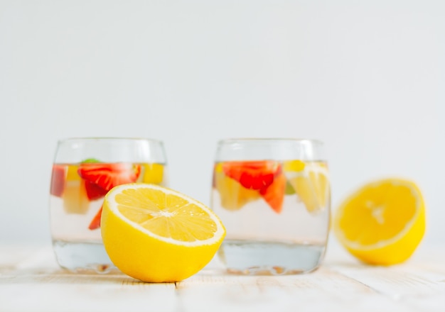 Mezzo limone e due bicchieri di limonata. bevanda rinfrescante estiva fatta in casa.