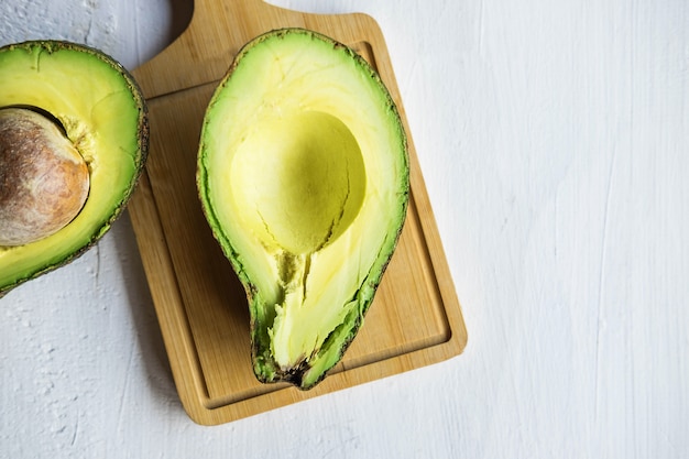 Mezzo taglio avocado su un tavolo di legno bianco