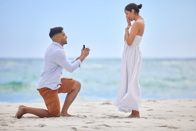 Mi rendi il più felice che sia mai stato. Inquadratura di un giovane che propone alla sua ragazza sulla spiaggia.