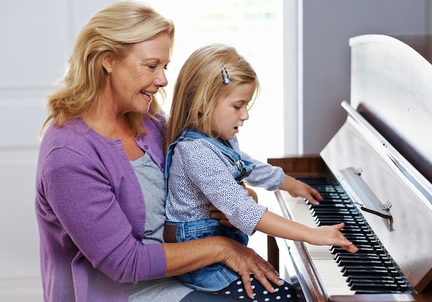 Mi ricorda sua madre A una bambina carina viene insegnato a suonare il pianoforte da sua nonna