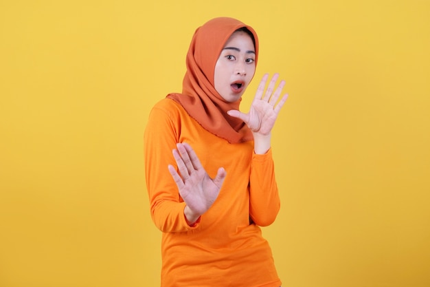 Mi rifiuto. una donna arrabbiata e imbronciata con l'hijab che indossa l'hijab alza il palmo in un gesto di arresto o di divieto, dice no aspetta un secondo, aspetta, fa un sorrisetto,