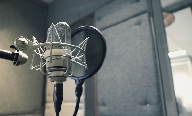 Microfono da studio con supporto antiurto e filtro antipop su treppiede professionale in camera di schiuma acustica