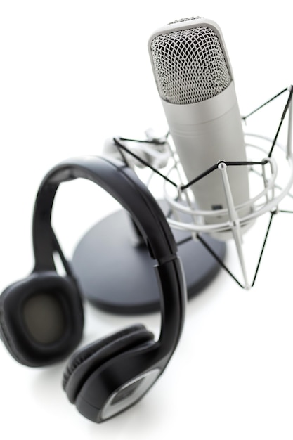 Microfono da studio per la registrazione di podcast con auricolare su sfondo bianco.