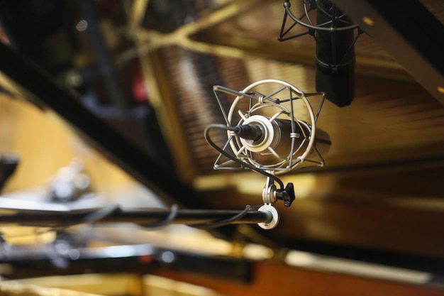 microfono da studio sullo sfondo di un pianoforte a coda aperto
