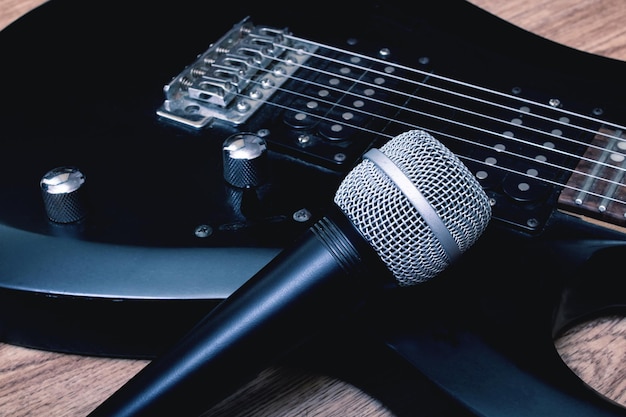 Microfono e chitarra su un fondo di legno