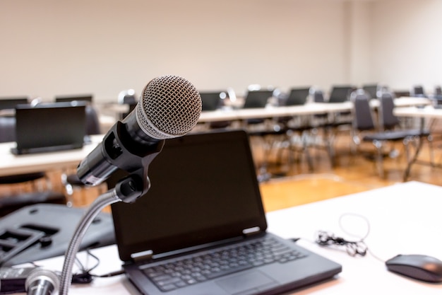 Microfono e laptop sul tavolo nella sala seminari