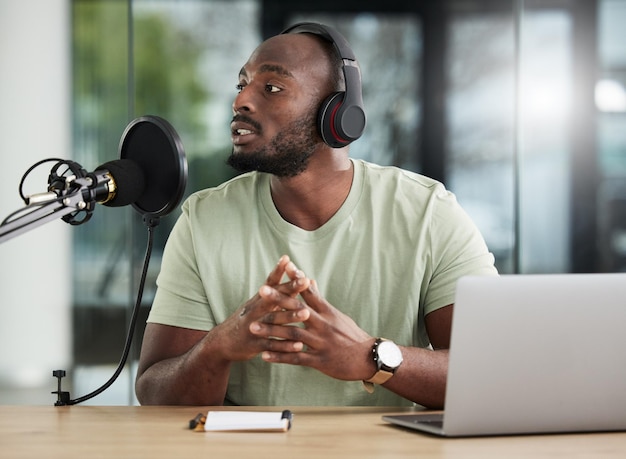 Microfono uomo nero e cuffie per laptop e radio DJ con comunicazione di notizie e apparecchiature audio Tecnologia podcast e multimedia con persona di sesso maschile che parla con annuncio e trasmissione