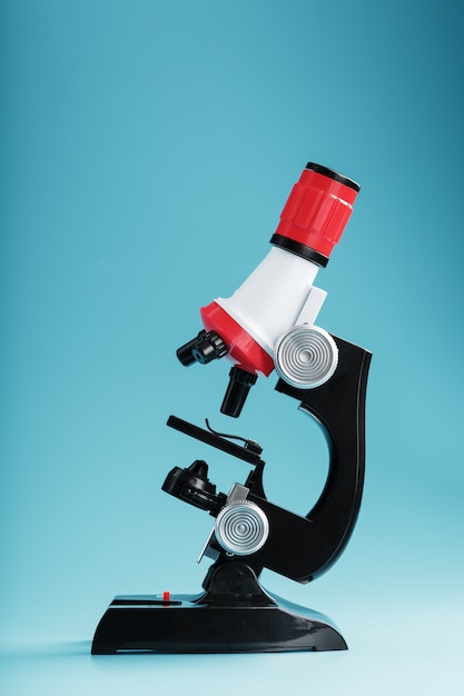 Microscopio per ricerche ed esperimenti medici di laboratorio su una superficie blu