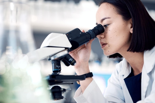 Microscopio scienziato o donna con cura medica di ricerca o controllo dei dati del campione in laboratorio Ricercatrice o dipendente asiatica analizzando il risultato metodo scientifico o attrezzatura di laboratorio per l'innovazione