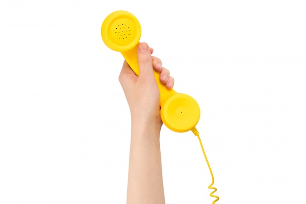 Microtelefono giallo in mano della donna isolata su bianco.