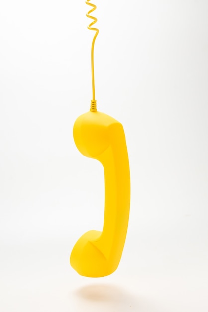 Microtelefono giallo isolato su bianco. Copia spazio.