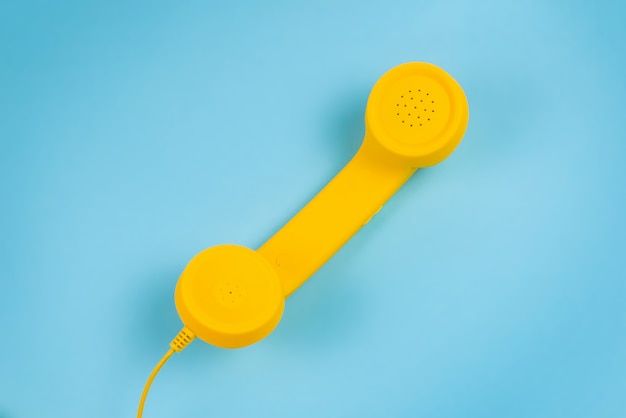 Microtelefono giallo su sfondo blu