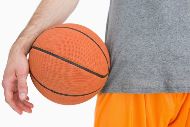 Midsection del primo piano dell&#39;uomo con pallacanestro