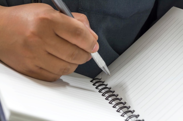 Photo midsection of man writing on notebook