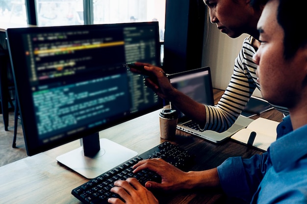 midsection of programmers discussing over computer in office
