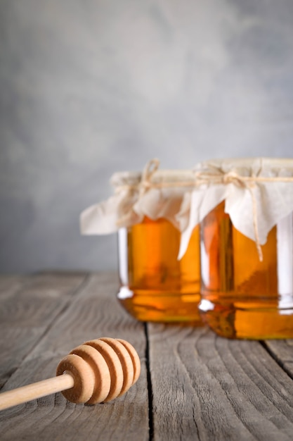 Miele aromatico di versamento nel barattolo, primo piano.