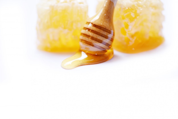 Miele con mestolo in legno e nido d'ape giallo dolce natura