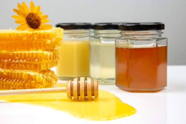 Miele di fiori freschi in favi e un cucchiaio di legno alimento vitaminico per la salute e la vita