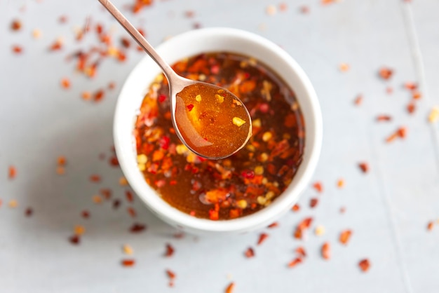 Miele di peperoncino piccante o caldo nel cucchiaio e nella ciotola da vicino