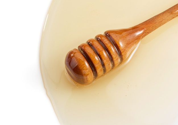 Miele e stick isolati su sfondo bianco