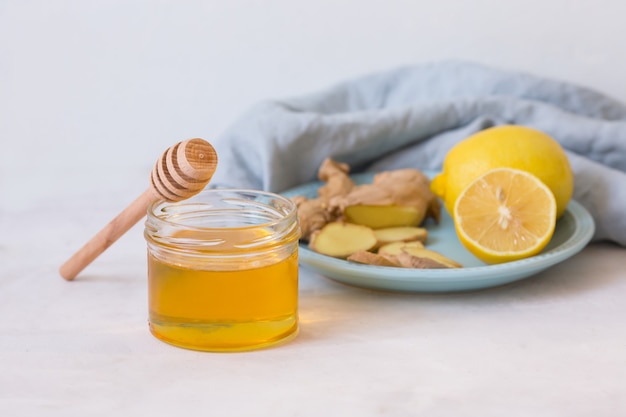 Miele, limone, zenzero su un tavolo luminoso. Rimedi popolari per il trattamento del raffreddore. Medicina fredda biologica. Rimedi naturali per il raffreddore