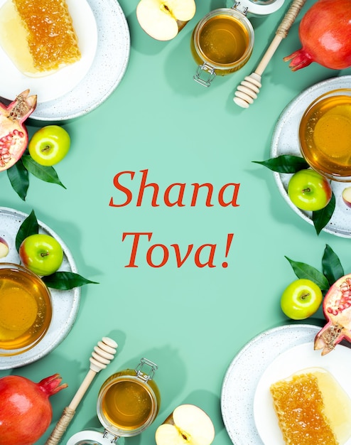 Miele, mela e melograno su fondo verde menta. Concetto Capodanno ebraico Felice vacanza Rosh Hashanah. Layout creativo di simboli tradizionali. Cornice per carte. Copia spazio. Shana Tova.