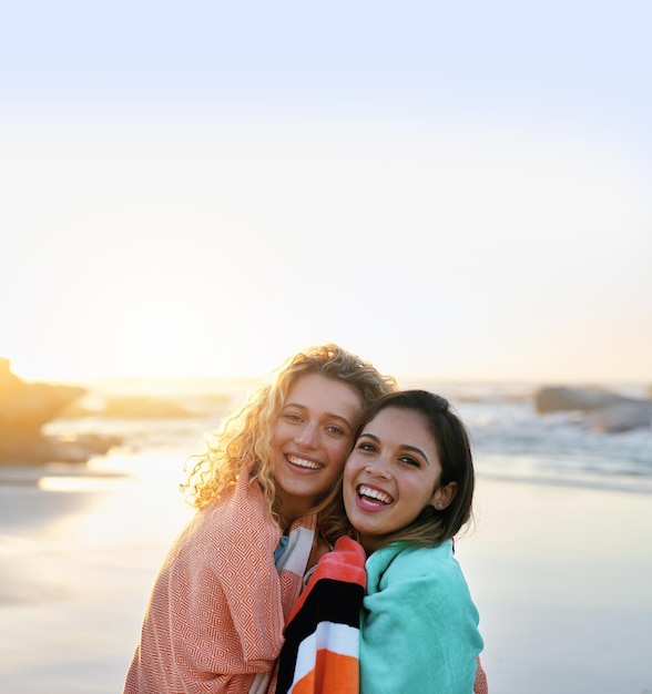 Migliori amici che si abbracciano sulla spiaggia al tramonto due belle donne sorridenti felici godendo dell'amicizia