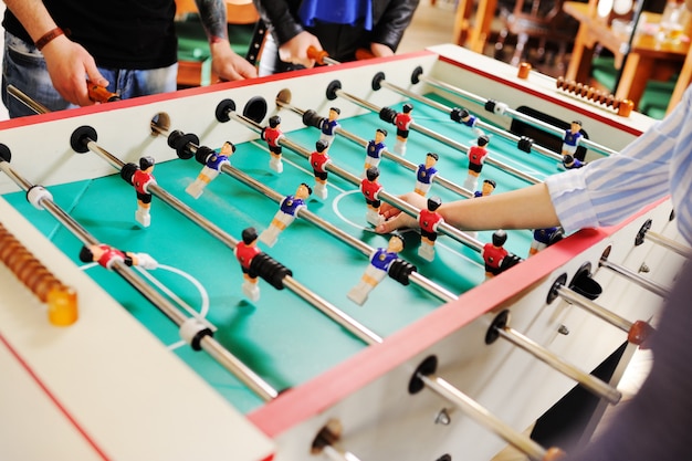 Migliori amici - ragazzi e ragazze giocano a calcio balilla.