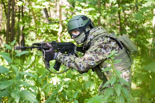 Militare nel bosco con una mitragliatrice. Preparare i militari per le ostilità. La mitragliatrice mira