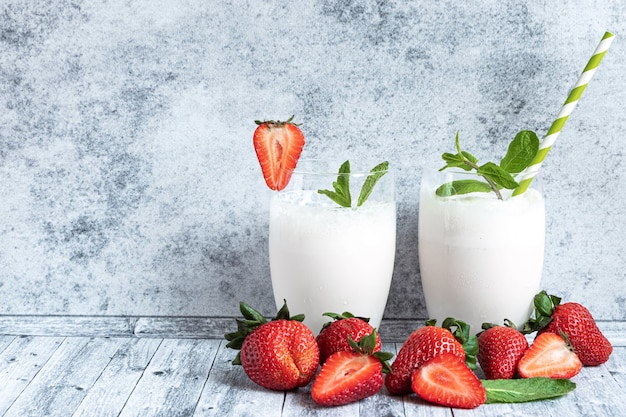 Milk shake in due bicchieri e fragole fresche