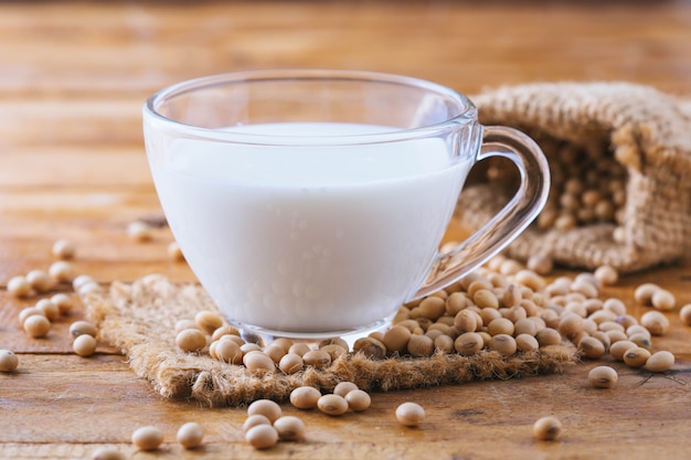 Milke di soia con i fagioli della soia su fondo di legno