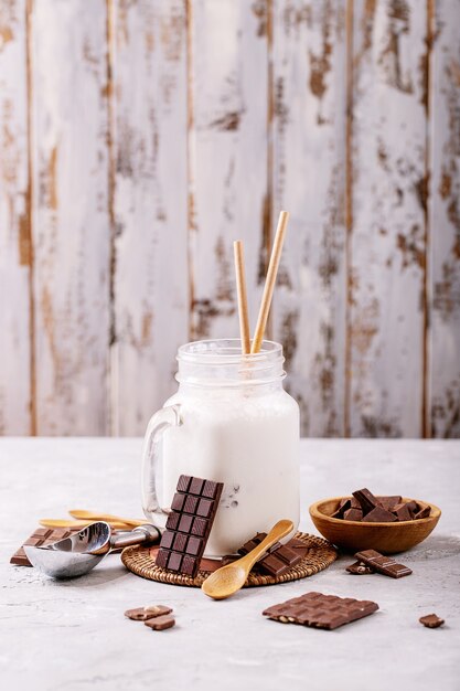 Milkshake alla vaniglia servito con cioccolato su sfondo bianco trama