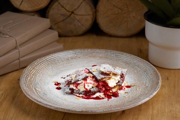 Millefoglie di dessert francese di pasta sfoglia e crema pasticcera e gelato su un piatto e su un primo piano di un tavolo di legno