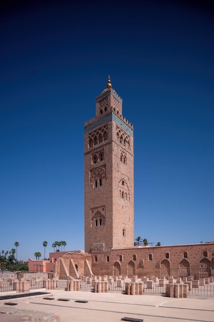 Minareto della moschea di Koutoubia in Marocco Marrakech e giardini durante il tramonto con cielo blu all'interno della Medina