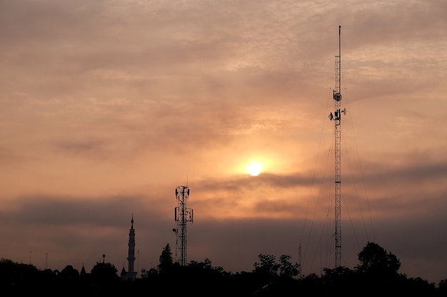 minareto della moschea e torre di comunicazione durante l'alba torre di trasmissione a radiofrequenza