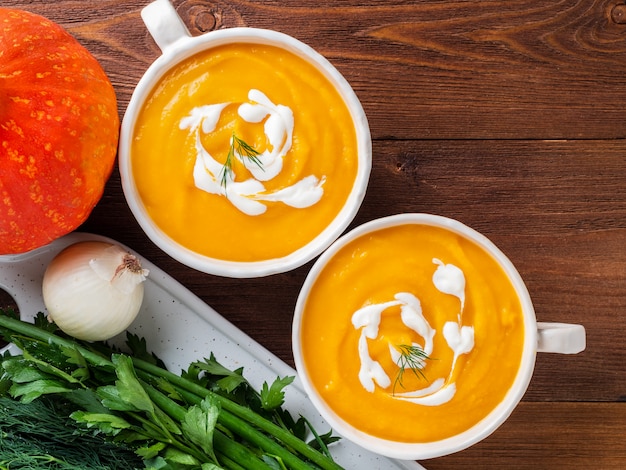 Minestra crema gialla deliziosa della zucca di due tazze con gamberetto e le verdure