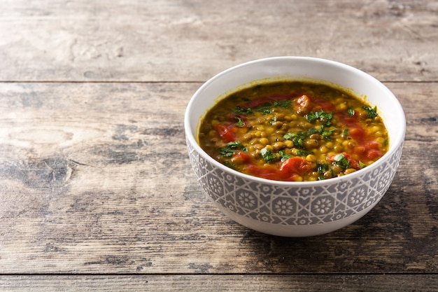 Minestra di lenticchia indiana dal (dhal) in una ciotola sulla tavola di legno. Copia spazio