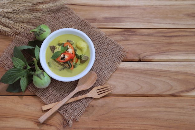 Minestra tailandese del curry verde su una tavola di legno con gli ingredienti