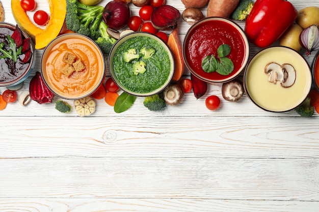 Minestre ed ingredienti di verdure sulla vista di legno e superiore bianca