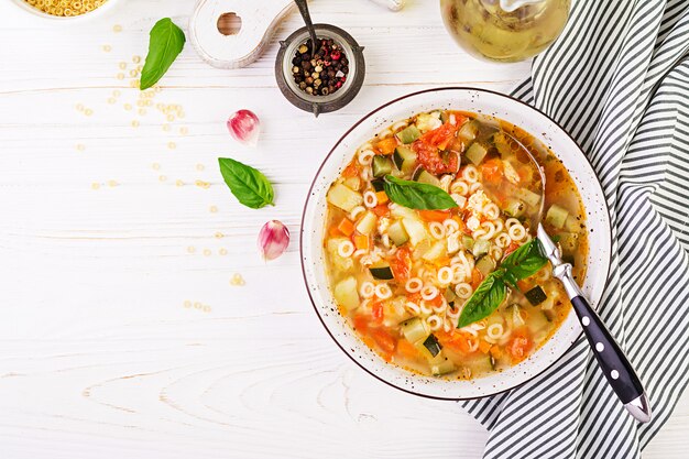 Minestrone, minestra di verdura italiana con pasta sulla tavola bianca. Zuppa vegana Vista dall'alto