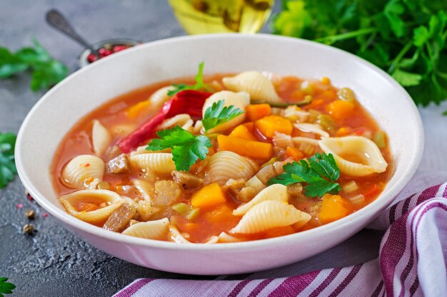 Minestrone, zuppa di verdure italiana con pasta sul tavolo. Cibo vegano